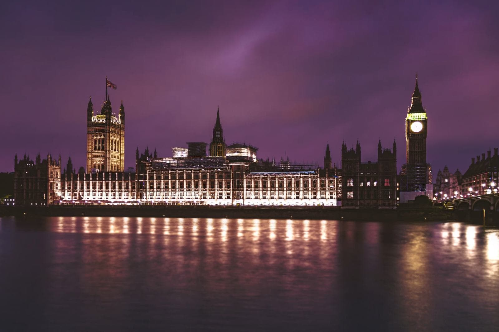Gece aydınlatılmış Parlamento binası ve Thames yansıması — Londra